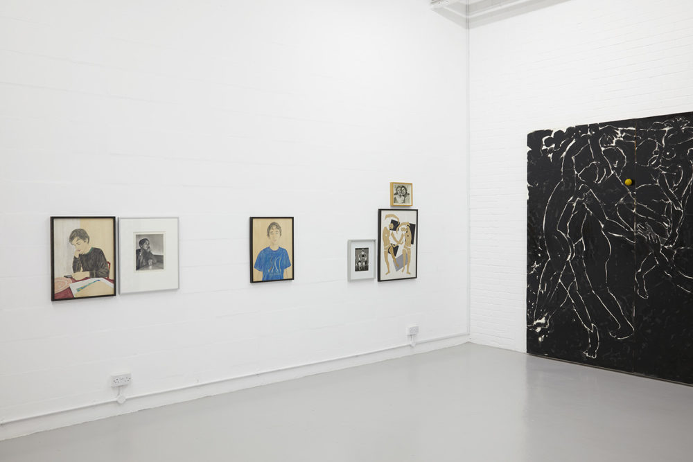 Various differing images hang on the white walls of the gallery space.