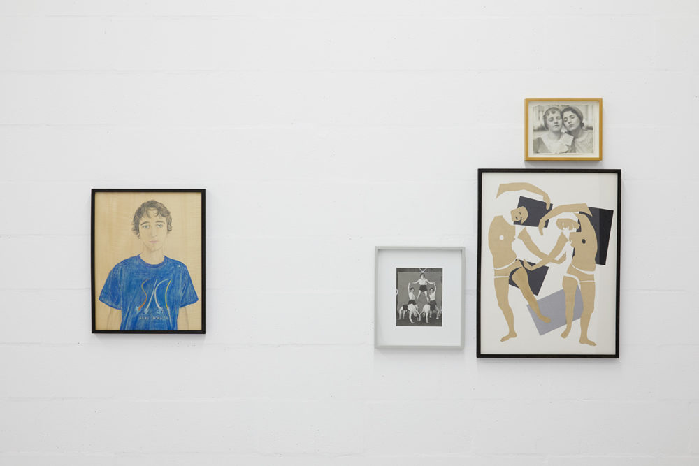 Four framed pictures hang next to one another. On the left, a pencil drawing of a young man. On the right, a triptych of pictures of performers.