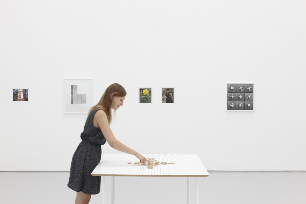 Installation view of Aurélien Froment Fröbel Fröbeled (2014). A visitor interacts with a wooden sculpture.