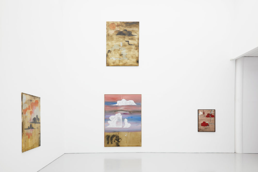 Four abstract paintings of clouds hang in the main gallery.