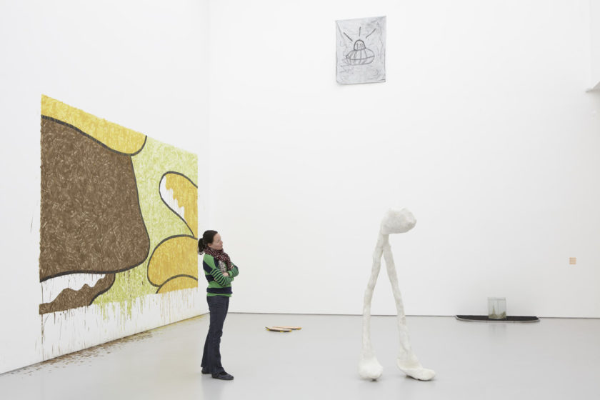 Installation view of Bloomberg New Contemporaries (2013) A visitor studies a large white sculpture in the shape of a wishbone.