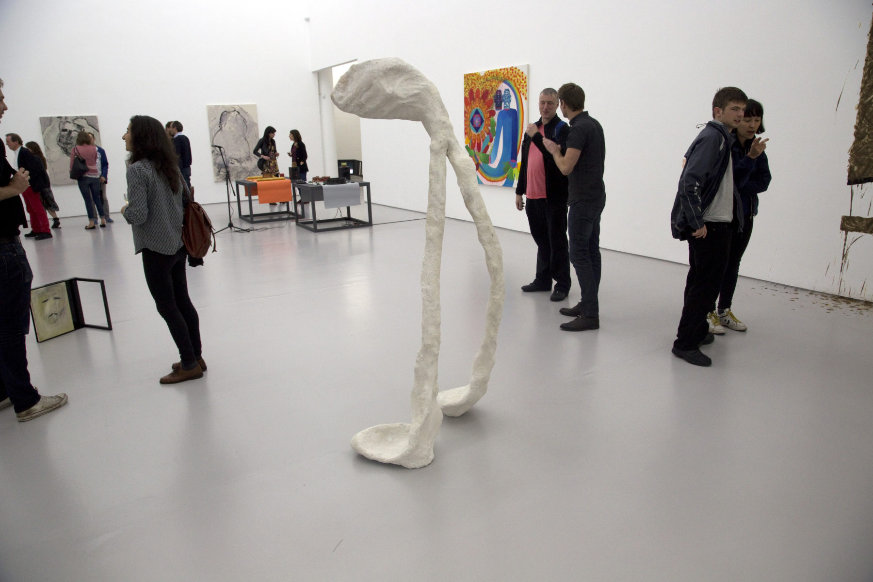 Installation view of Bloomberg New Contemporaries (2013) Visitors interact with the works. In the foreground is a large sculpture in the shape of a wishbone.
