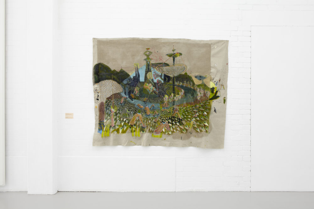 Installation view of Bloomberg New Contemporaries (2013). A busy textile piece showing a garden scene.