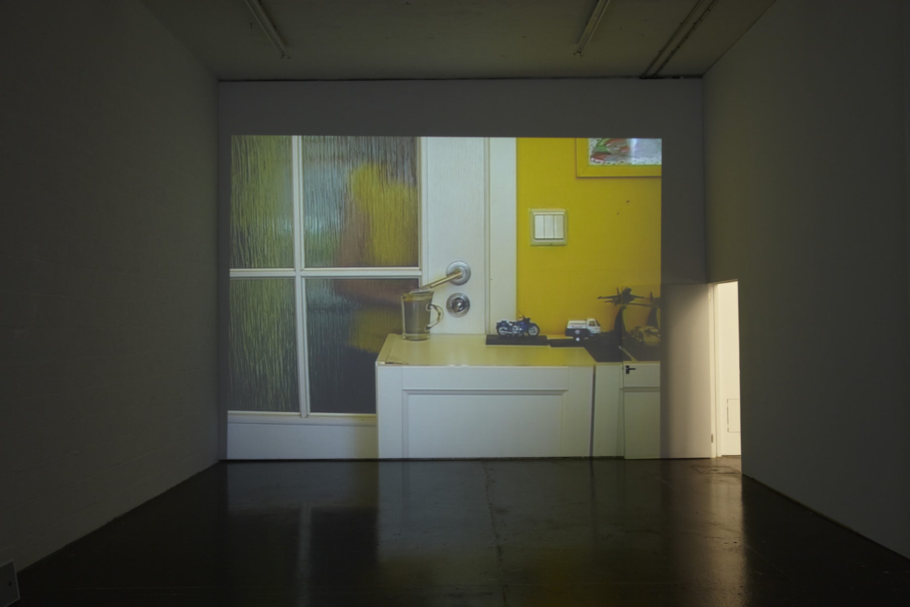 Installation view of Cezary Bodzianowski, Tea Back (2011). A projection of a domestic scene.