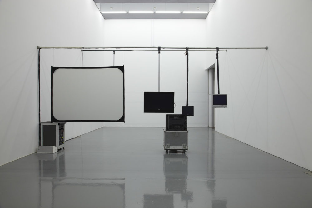 Installation view of Cezary Bodzianowski, Tea Back (2011). A bright white room shows five screens, nothing shows on the screens.