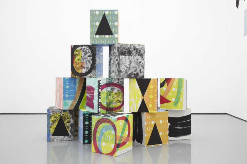 Installation view of Ciara Phillips and Corita Kent, Pull Everything Out (2012) A pyramid of brightly coloured boxes sits in the gallery.