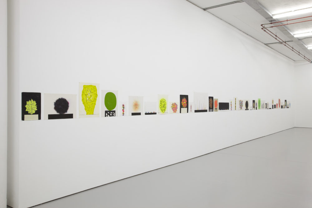 Installation view of David Batchelor Flatlands (2013). Small colourful prints hang on the gallery walls.