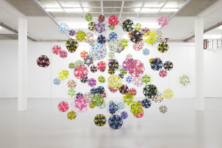 Installation view of David Batchelor Flatlands (2013). Various plastic balls are suspended from the ceiling.