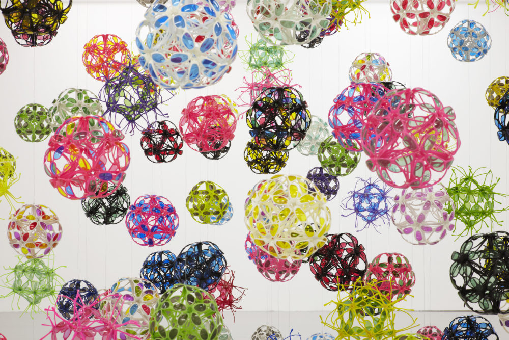 Installation view of David Batchelor Flatlands (2013). Various plastic balls are suspended from the ceiling.