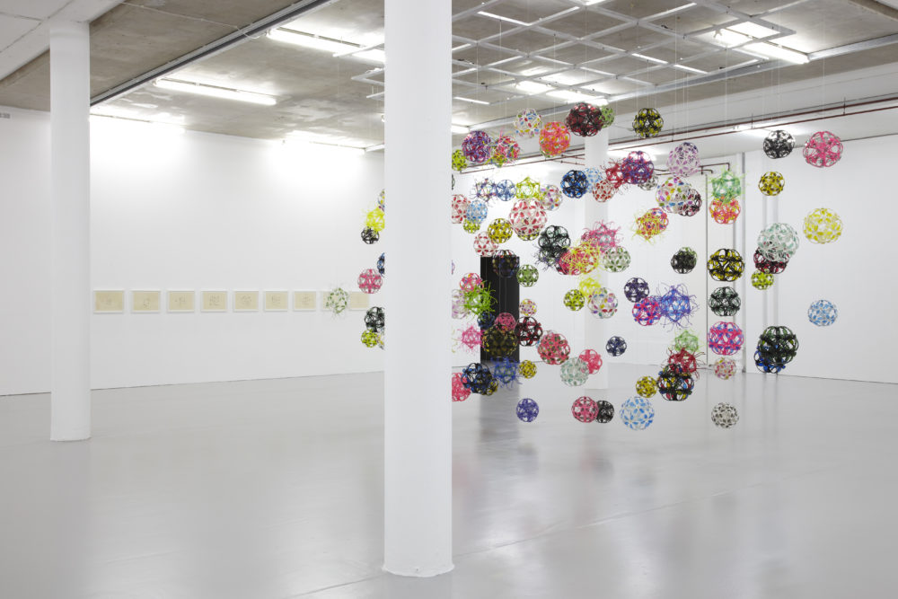 Installation view of David Batchelor Flatlands (2013). Various plastic balls are suspended from the ceiling.
