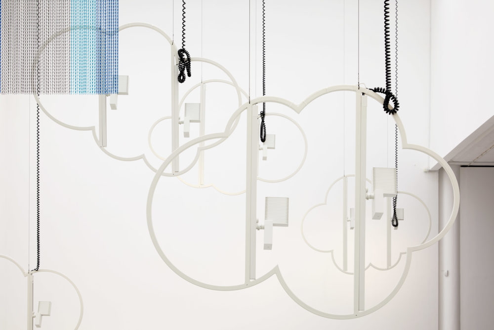 Structures outlining the shape of clouds are hung from the ceiling.