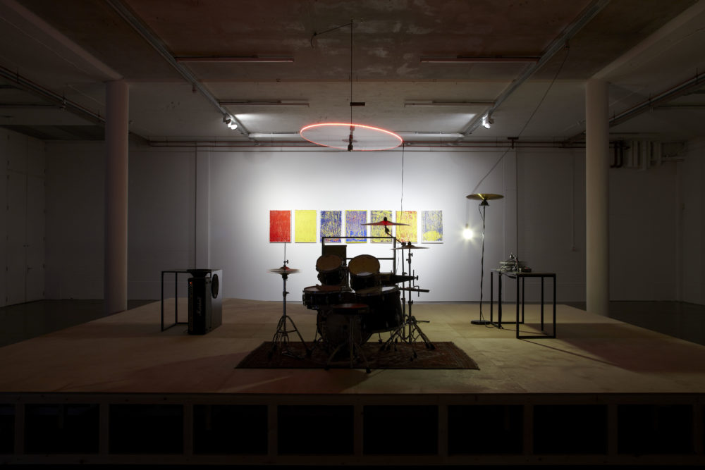 Installation view of Haroon Mirza. A formica covered glass display unit is lit up in the centre of the gallery.