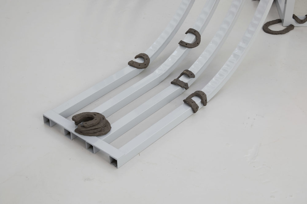 Harriet Bowman, (Car) display unit (2018) Steel, display items (mixed media); Horseshoes (2018) Vulcan black stoneware clay (fired) Installation view, All Round-er (sad sale), Spike Island (2018) Photograph by Stuart Whipps