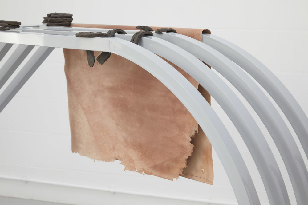 Harriet Bowman, (Car) display unit (2018) Steel, display items (mixed media) (detail); Horseshoes (2018) Vulcan black stoneware clay (fired); Accessories: leather flats. Installation view, All Round-er (sad sale), Spike Island (2018) Photograph by Stuart Whipps