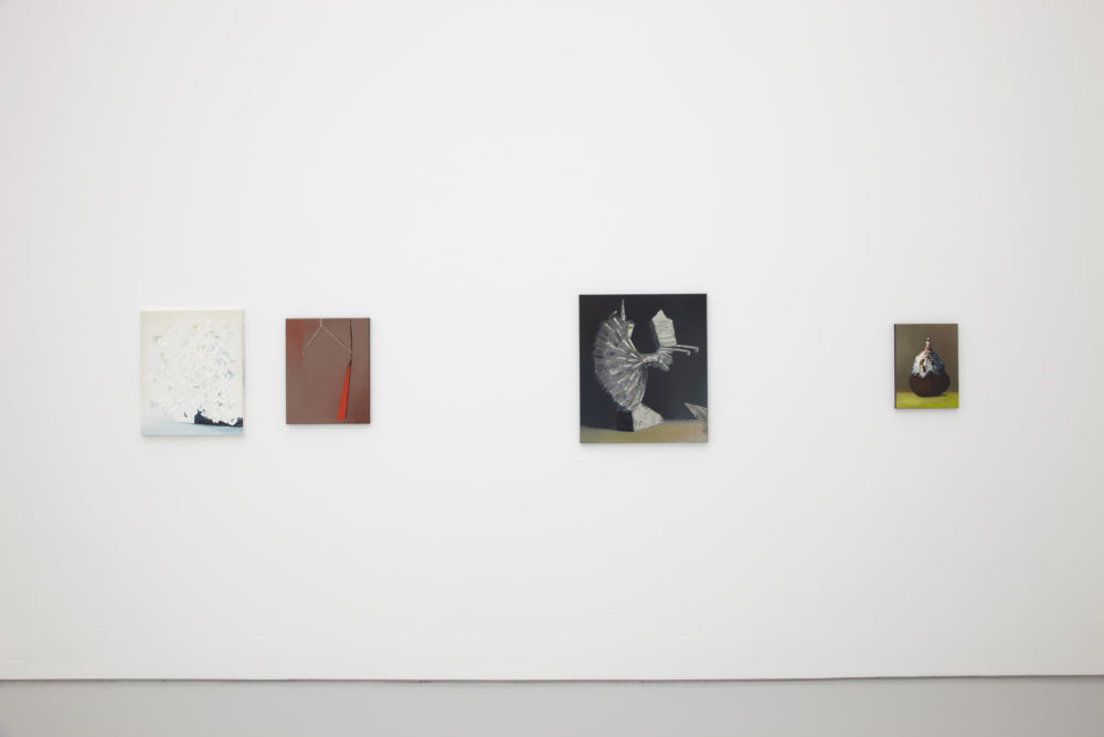 Installation shot: Four unframed paintings hang on a white wall.