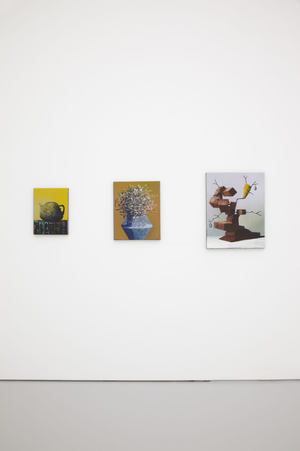 Installation shot: Three unframed paintings hang on white walls.