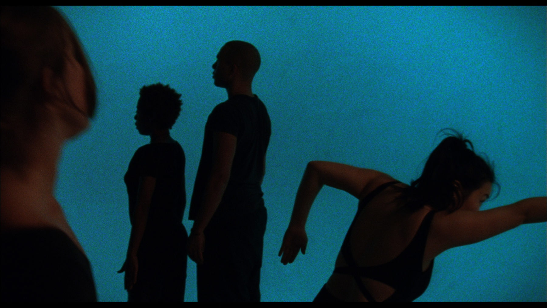 Film still of Jesse Jones The Struggle Against Ourselves (2012). Three people stand in odd positions.