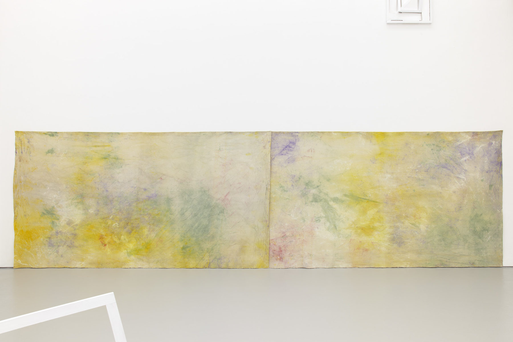 Installation view of Jessica Warboys Ab Ovo (2013). Two large multi pastel coloured textiles hang on the gallery wall next to one another.