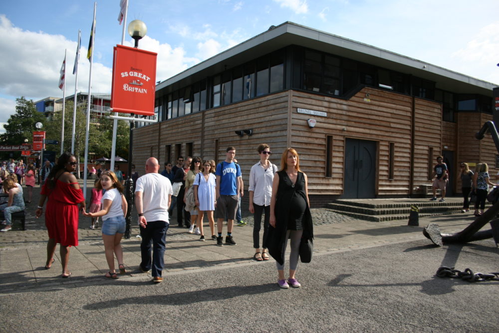 A group of people stand in a line in a tourist area.