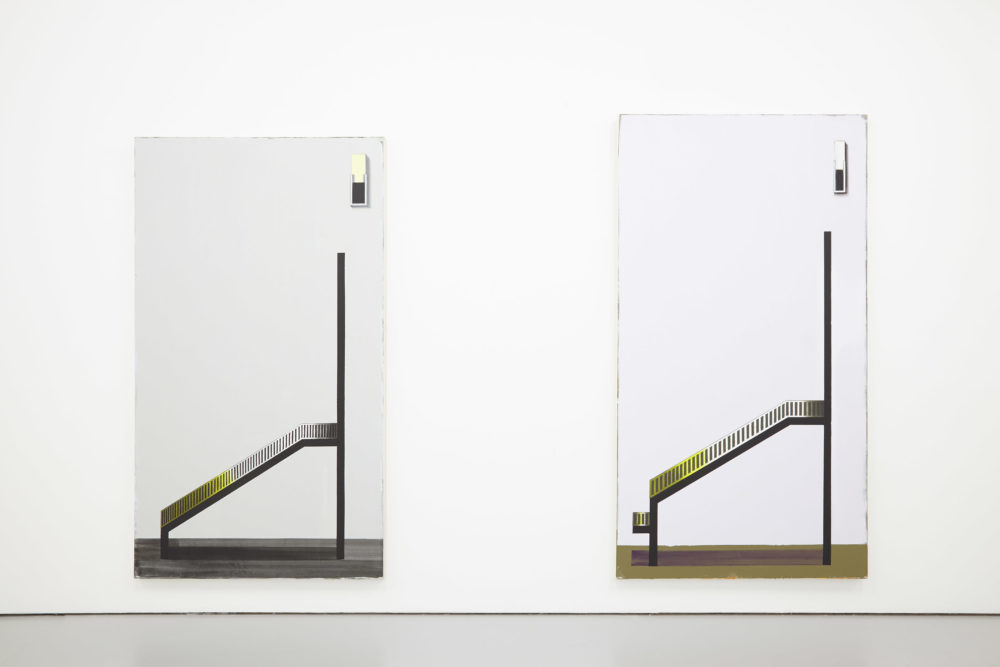 Two paintins hang in the gallery. They are predominantly black and white but there is a flash of yellow. They depict sloping structures, pictured from side-on.