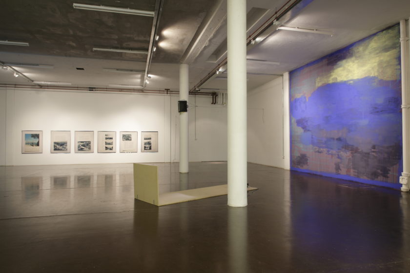 Installation view of Part-ilha, A River Ain't Too Much to Love (2011). A wall is painted floor to ceiling with abstract brush strokes of blue, mauve and lime green.