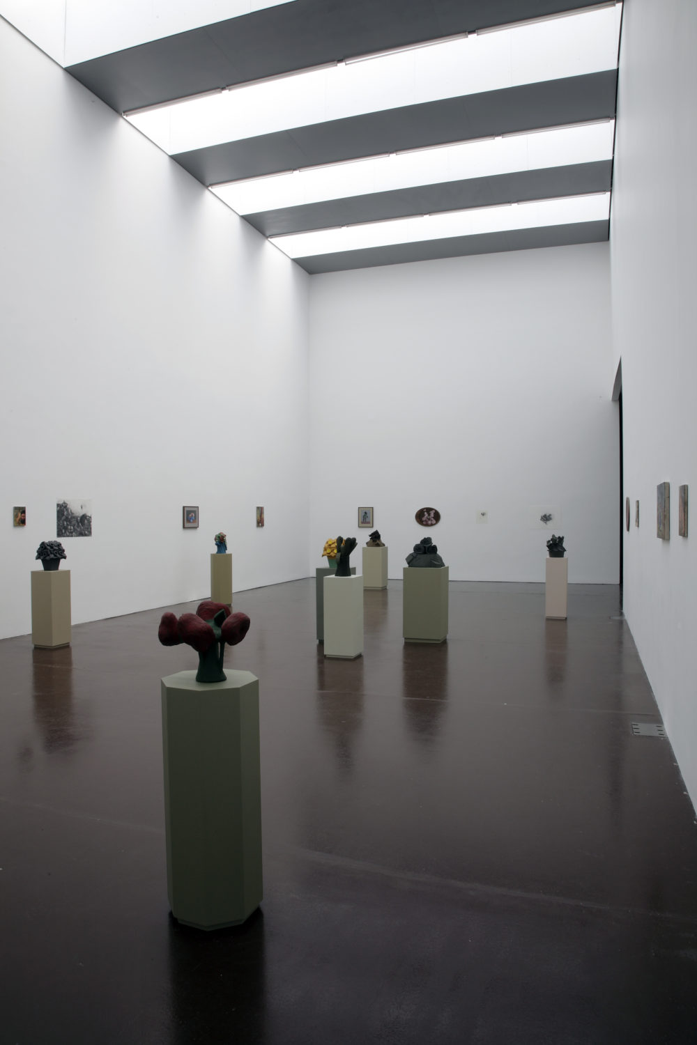 Installation view of Prophet (2008). Geometric sculptures made of clay sit on plinths. There are eight plinths in total.