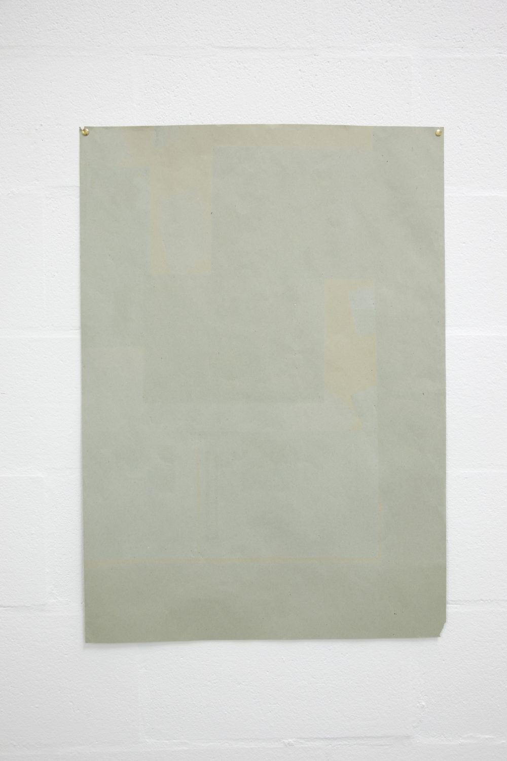 Installation view of Sara MacKillop, Faded Paper (2011). A sheet of green sugar paper, faded by the sun, is pinned to the white gallery wall.