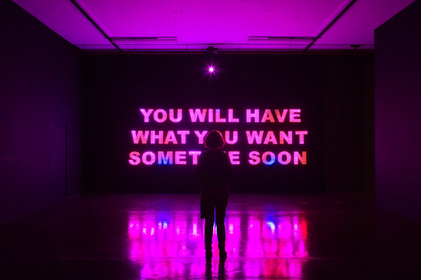 Installation view of Savage, You Will Have What You Want Sometime Soon (2011). A visitor stands in front of a projection of 