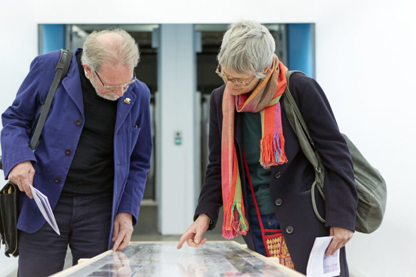 Two visitors study a table top at Open Studios 2017.