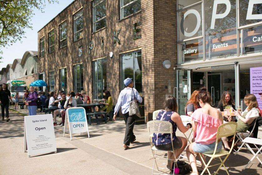 The front of the Spike Island building during an Open Studios weekend: The sun is shining and lots of people are sat outside in the sun enjoying refreshments.