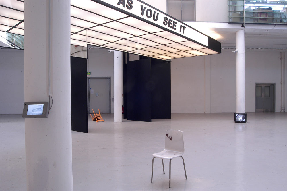 Installation view of Spin Cycle (2004). A canopy that looks like a cinema entrance hangs from the gallery ceiling, 