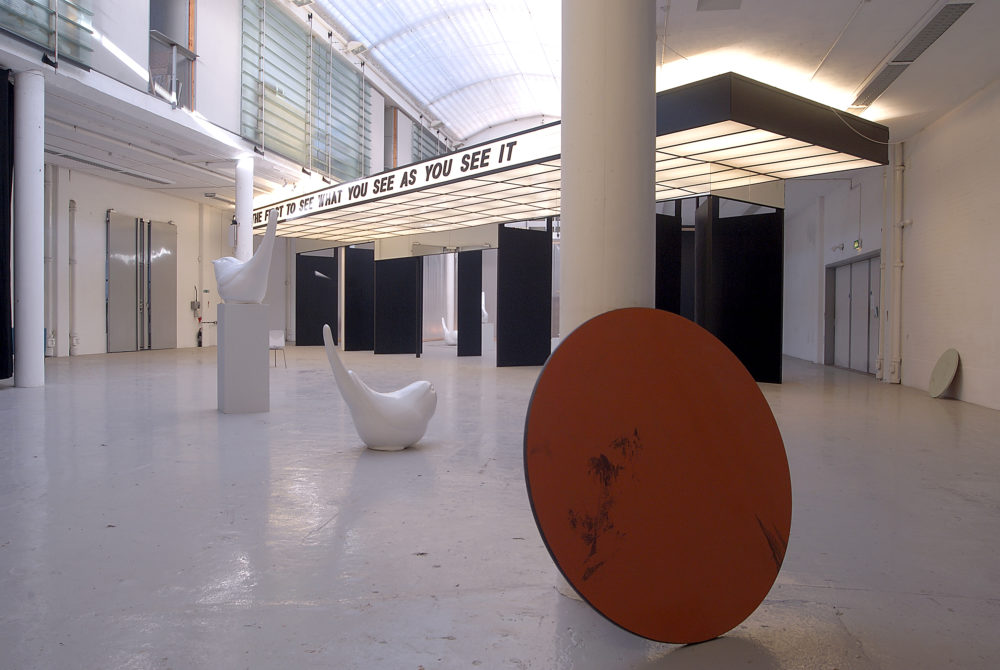 Installation view of Spin Cycle (2004). A canopy that looks like a cinema entrance hangs from the gallery ceiling, 