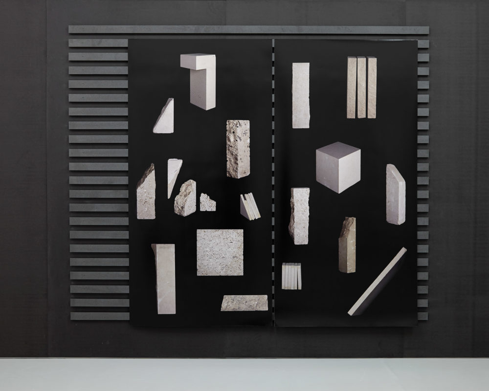 Computer generated illustrations of rocks are printed on black paper and applied to wooden slats.