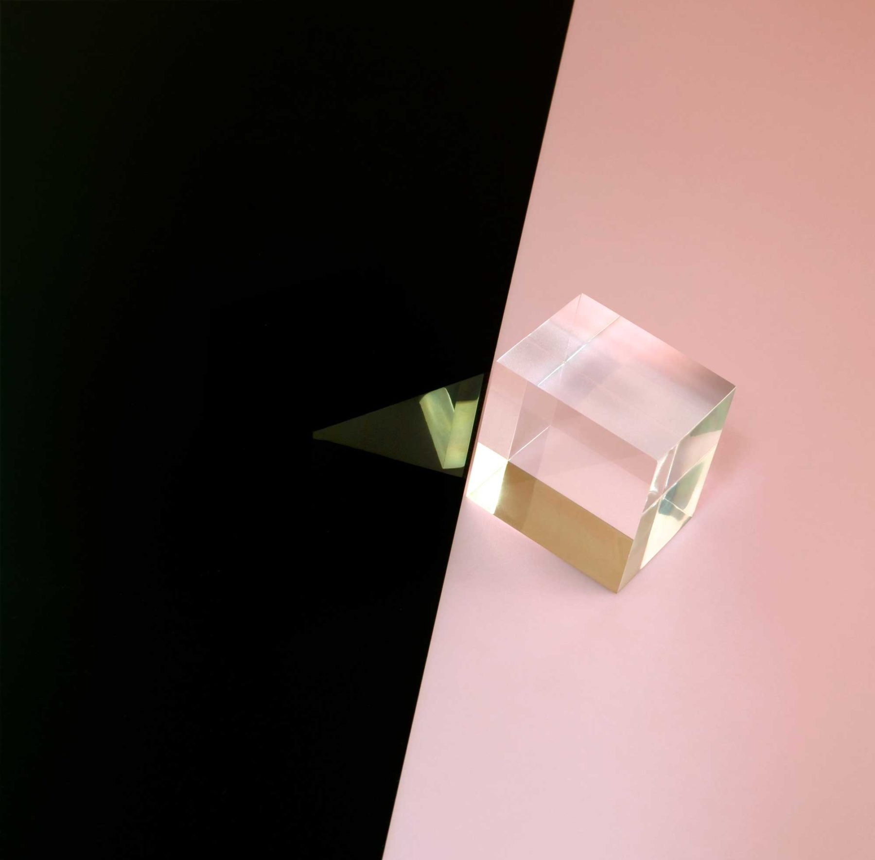 Installation view of Suzanne Mooney, The Edge of Collapse (2011). A clear perspex cube sits on the edge of a split between baby pink and black.