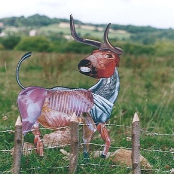 A collaged image of a deer in a field. The deer is made from various photographs of butchered meats.