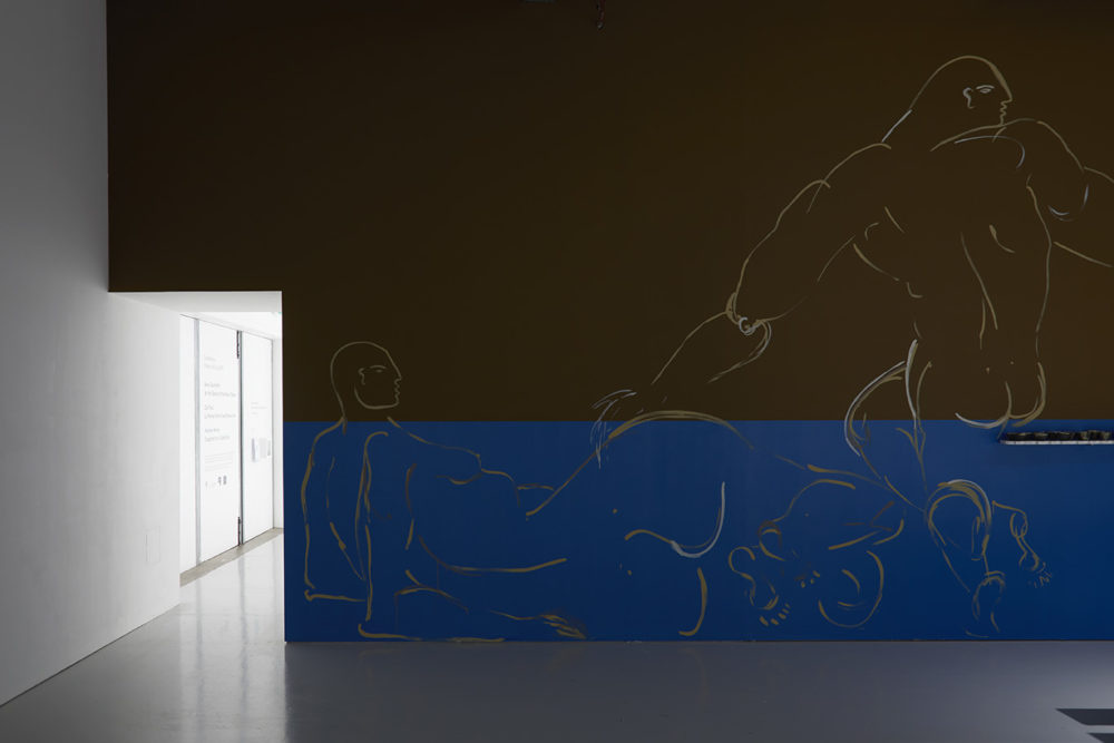 The gallery wall is painted in two vertical halves. The top half is painted brown and the bottom is blue. Over these colours, very large line paintings of nude figures sit.