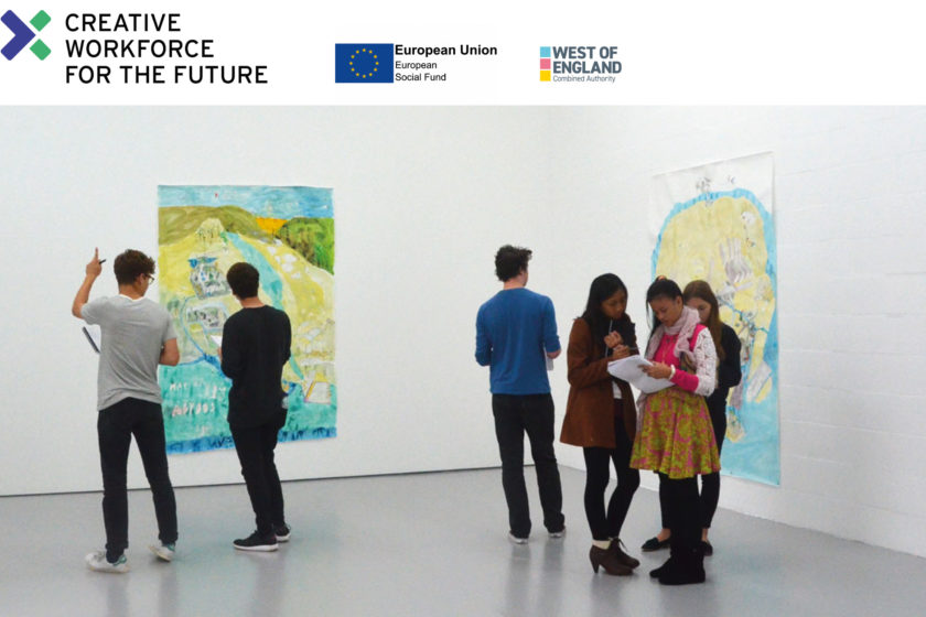 A photograph of a group of young people looking at artwork in a gallery space