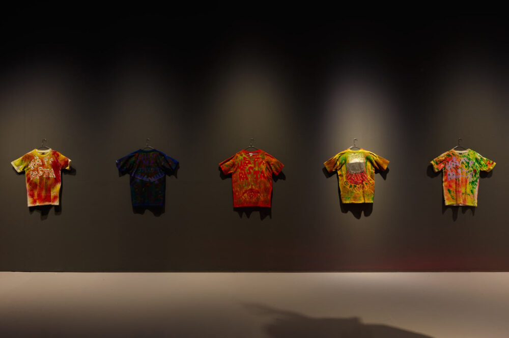 Gallery view of five colourful, hand-painted t-shirts