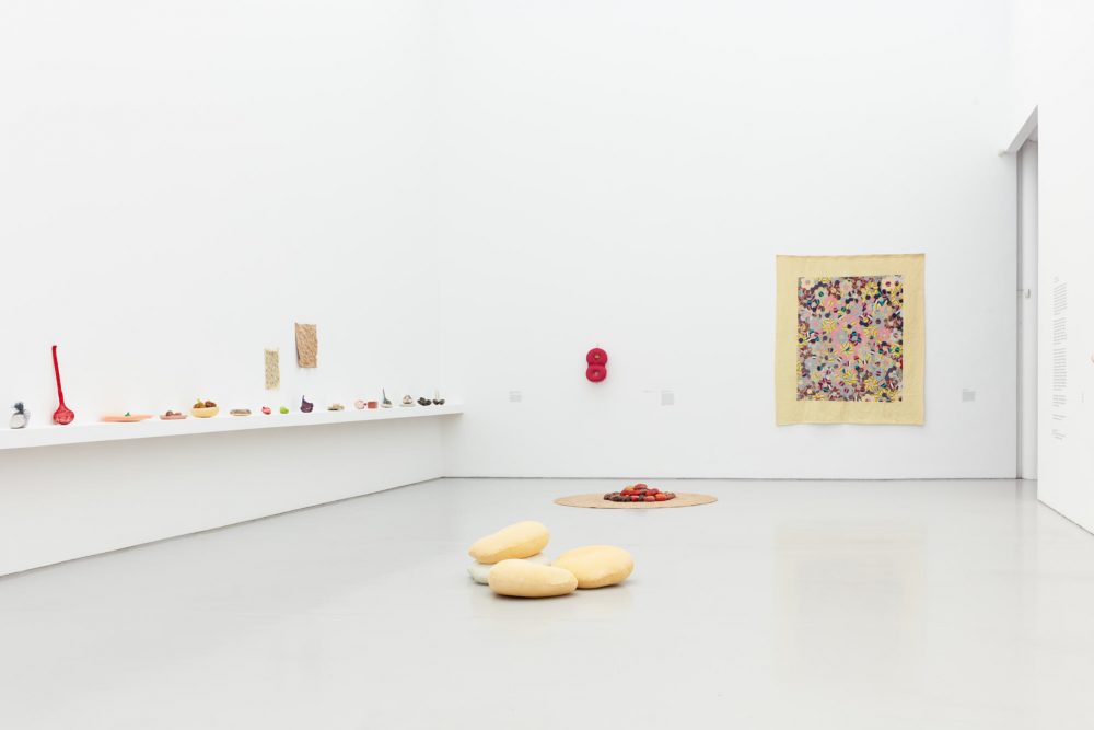 A wide angle view of Veronica Ryan's exhibition Along a Spectrum at Spike Island, a gallery space filled with light and colourful sculptures and objects positioned on the gallery floor and walls