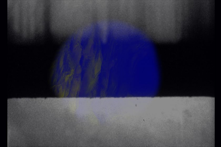 Production still: A blue circle sits behind a white rectangle with white rectangular shadows at the top of the frame