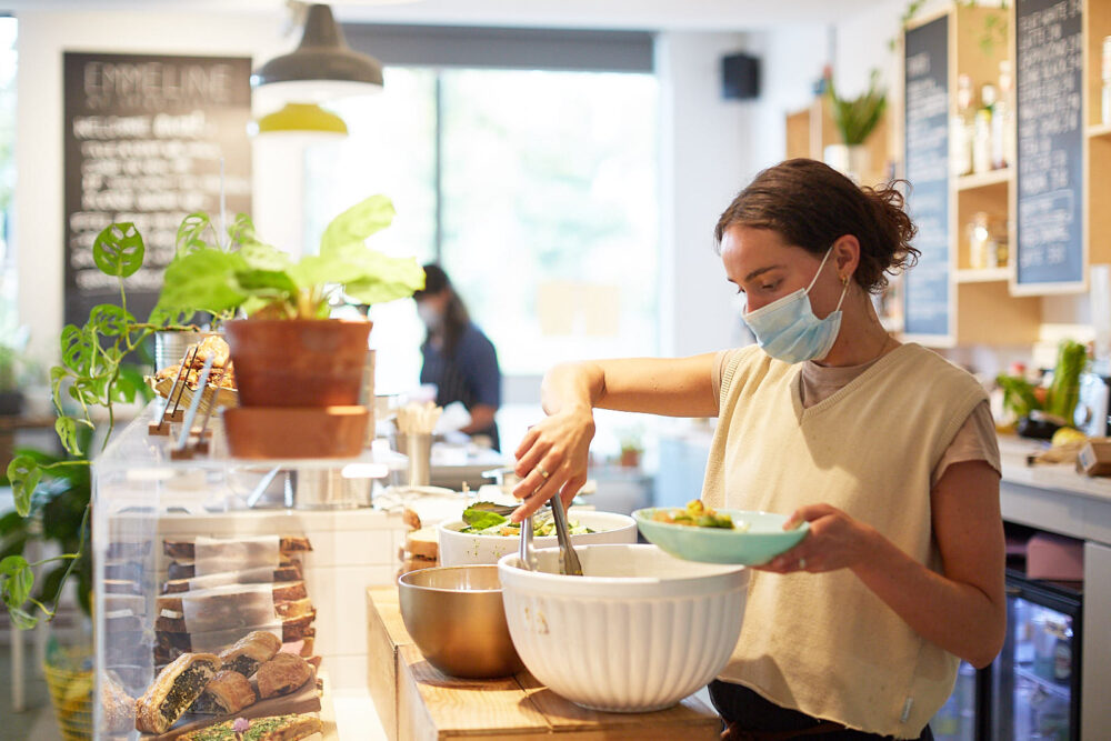 a woman serving behind a cafe bar