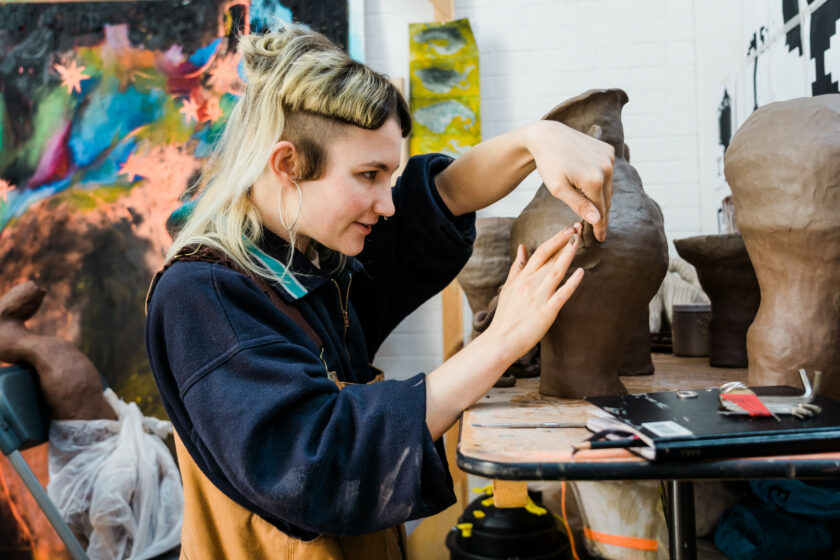 A photograph of artist Izzy Mooney in her studio at Spike Island