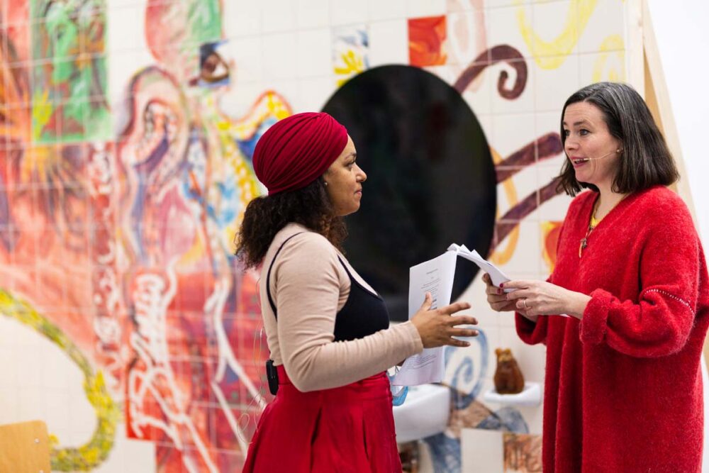Photograph of Lucy Stein and Maria Christoforidou Performing the Question in the exhibition Wet Room at Spike Island