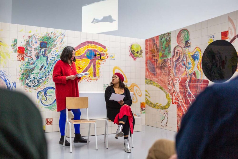 Photograph of Lucy Stein and Maria Christoforidou Performing the Question in the exhibition Wet Room at Spike Island