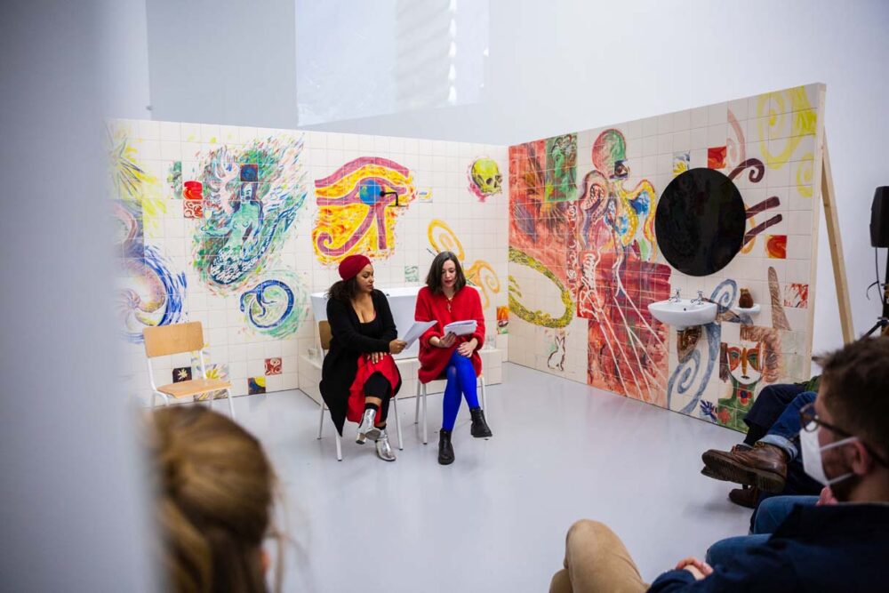 Photograph of Lucy Stein and Maria Christoforidou Performing the Question in the exhibition Wet Room at Spike Island