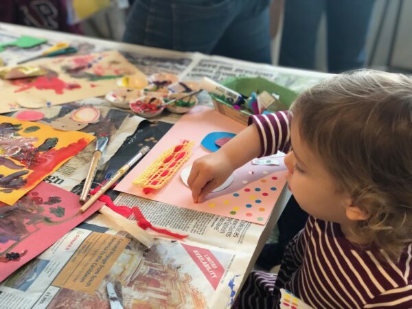 A toddler making art at a table