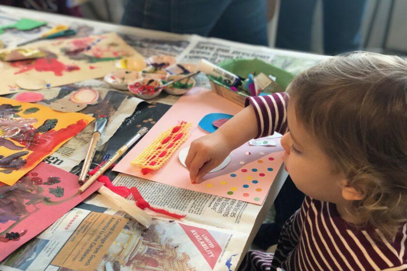 A toddler making art at a table