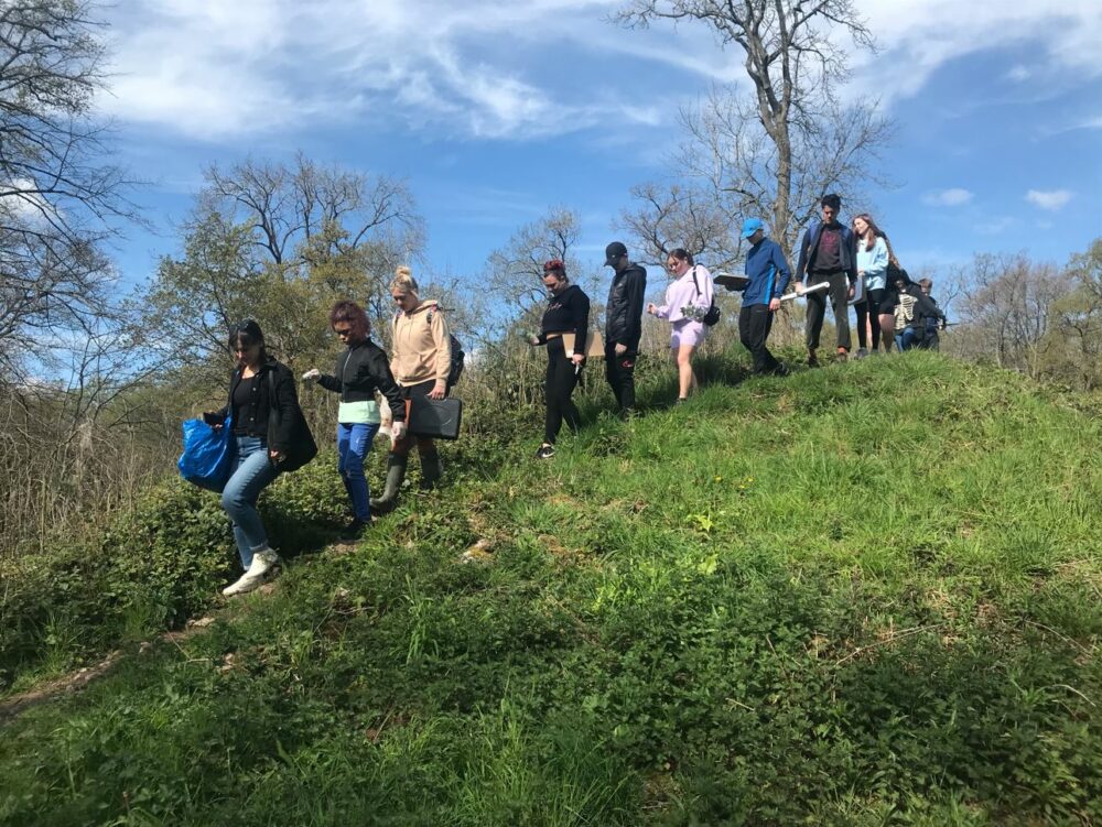 Photograph of the Hartcliffe Young People walking over a grassy hill