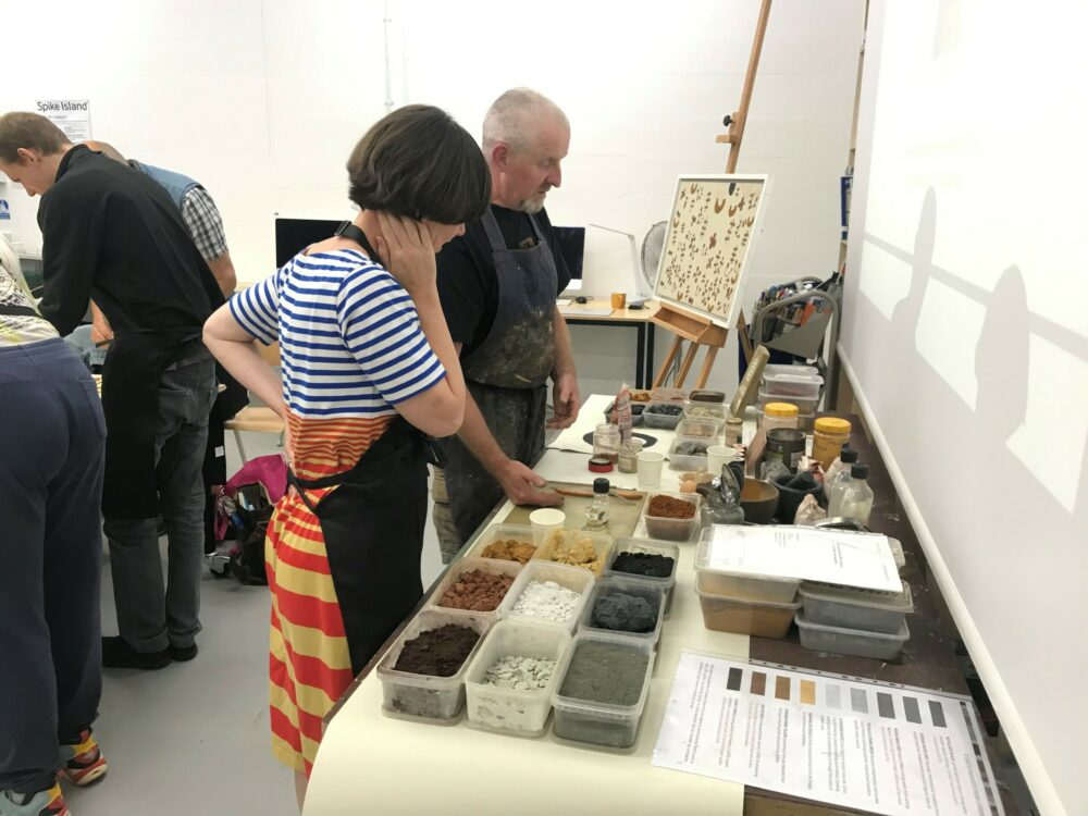 Pohotgraph of two artists looking at materials.