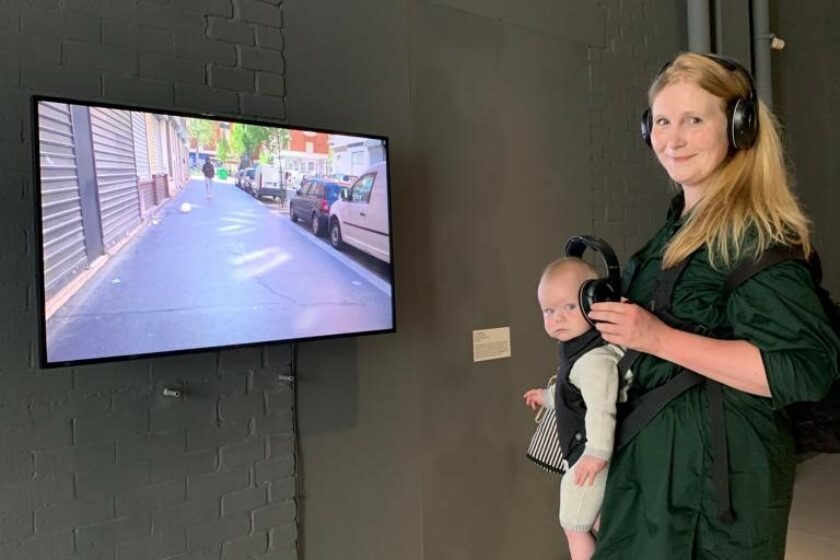A photograph of a women and her baby wearing headphones.